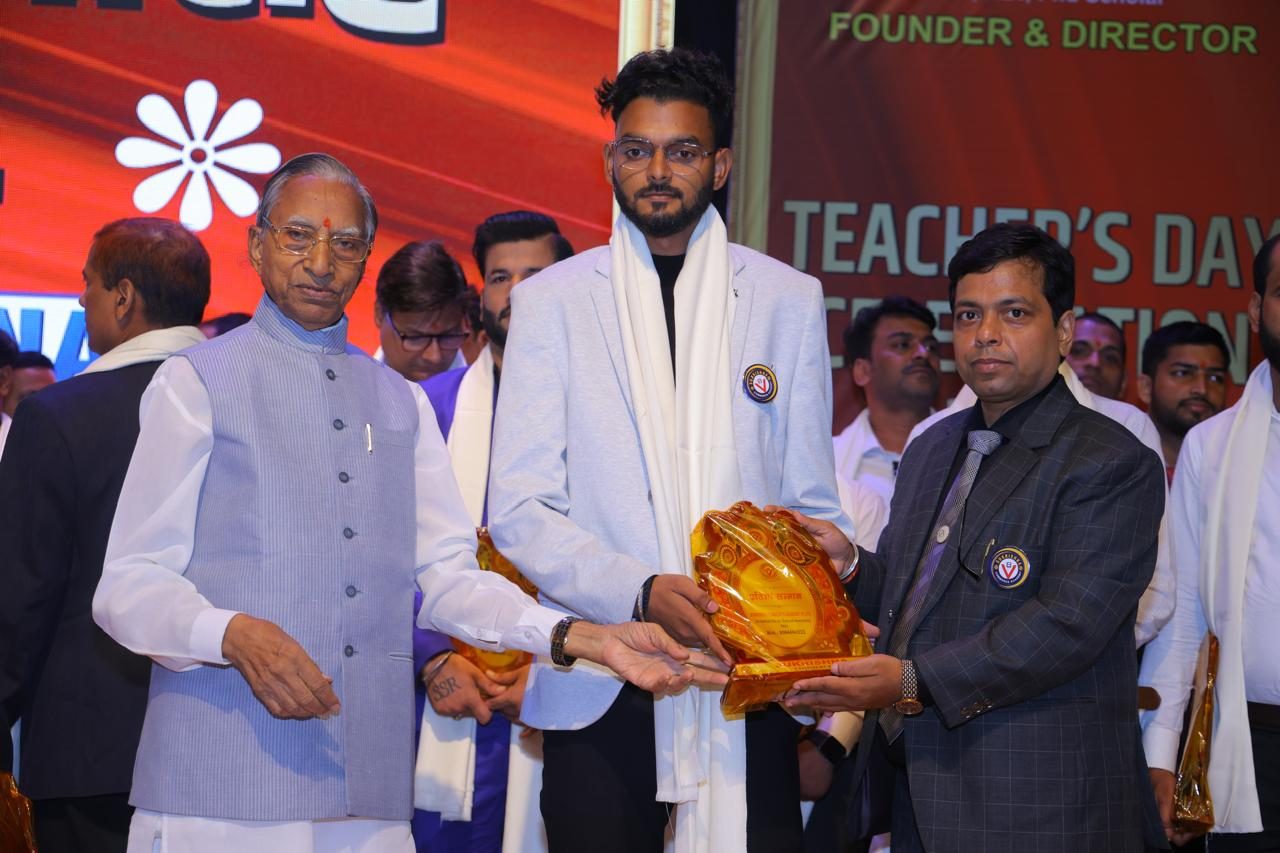 Piyush Kumar receiving an award on stage at a felicitation ceremony