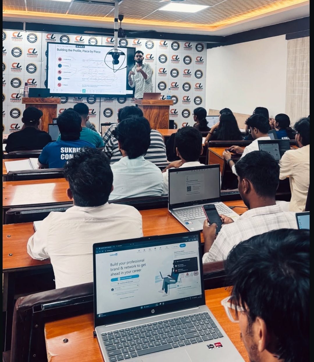 Piyush teaching a digital marketing workshop to a classroom of students with laptops open to LinkedIn